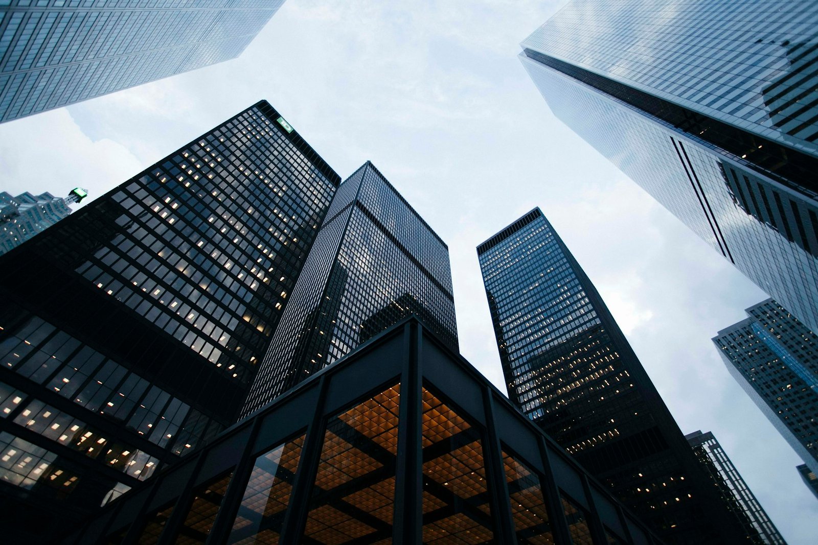 Glass tower facade reflecting a city skyline at dusk